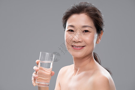 中年女人拿着玻璃杯喝水快乐高清图片素材