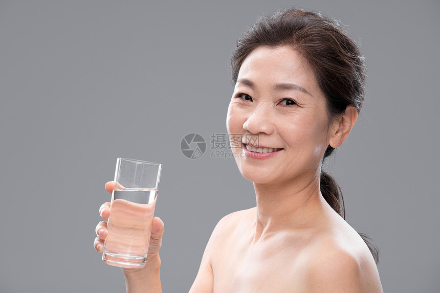 中年女人拿着玻璃杯喝水