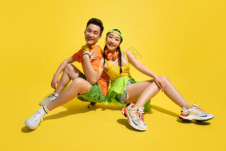 情侣运动鞋坐在滑板上的青年情侣背景
