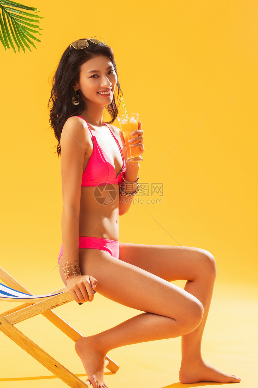 赤脚自信人沙滩上喝饮料的比基尼美女图片