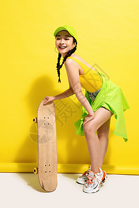 扶着滑板的年轻女孩图片
