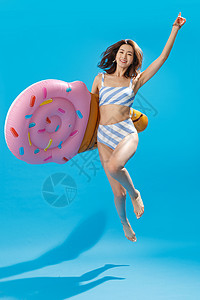 乐趣摄影半空中抱着冰淇淋形状的浮排跳跃的泳装美女图片