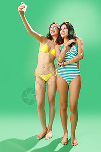 健康的度假苗条拿手机自拍的泳装闺蜜图片