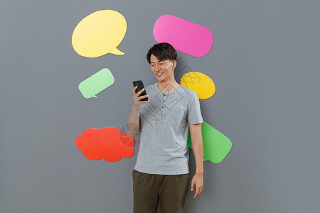 灰色背景思想气泡框对话气泡框拿手机发短信的青年男士图片