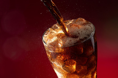 气泡特写可乐倒入装满冰块的杯中背景