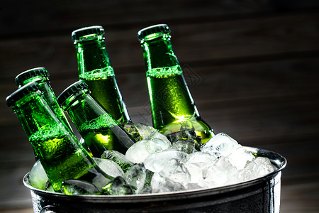 气泡特写冰块和冰镇玻璃瓶啤酒背景