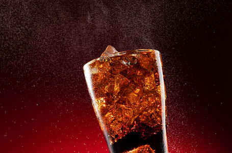 可乐倒入装满冰块的杯中图片