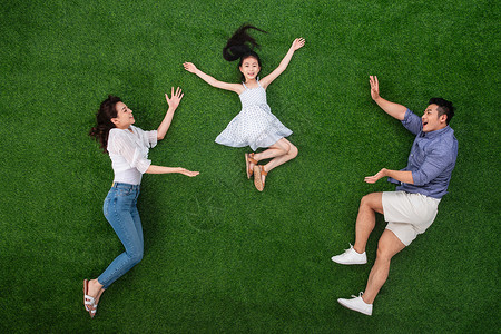 青年女人活力奔跑草地上做游戏的一家三口背景图片