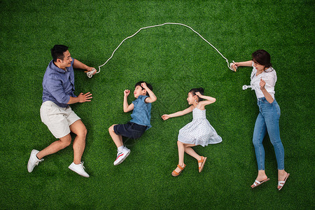玩跳绳女孩一家四口在草地上跳绳背景