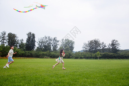 几个女孩快乐的东方儿童在草地上放风筝背景