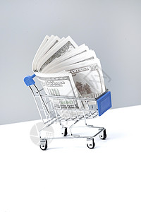 垂直构图棚拍现代购物车和美国百元钞票背景图片