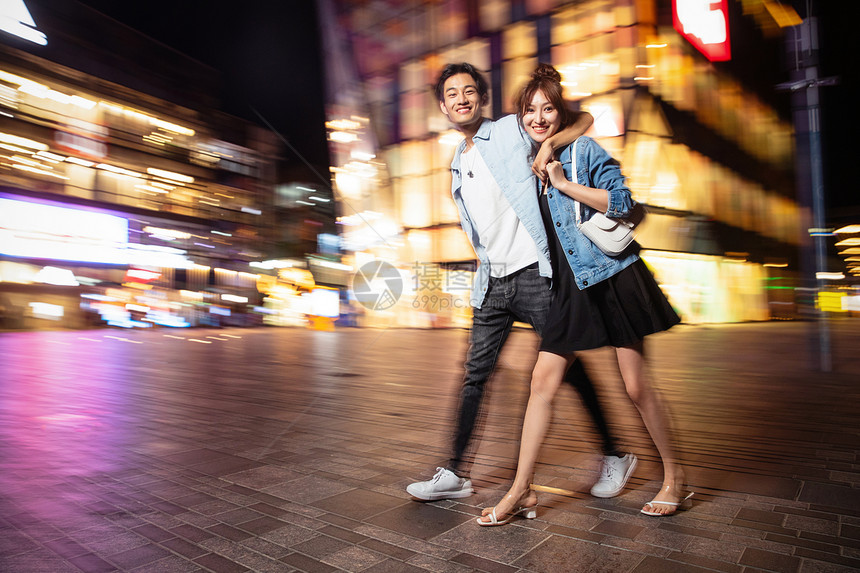 健康生活方式青年夫妇运动模糊夜晚逛街的快乐情侣图片