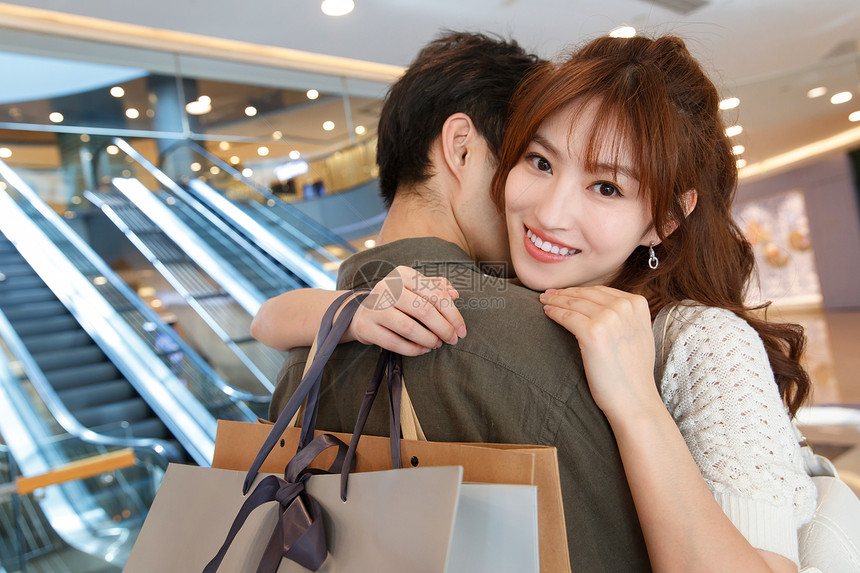 东亚夫妇彩色图片拿着购物袋拥抱的幸福情侣图片