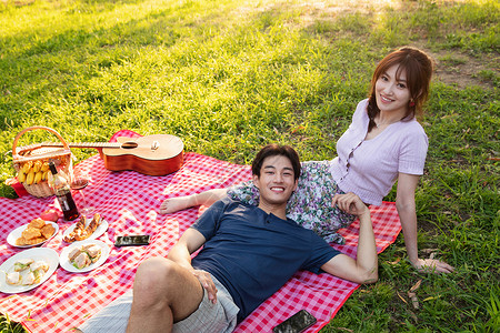 躺着约会的情侣25岁到29岁野炊饮食躺在草地上的幸福情侣背景