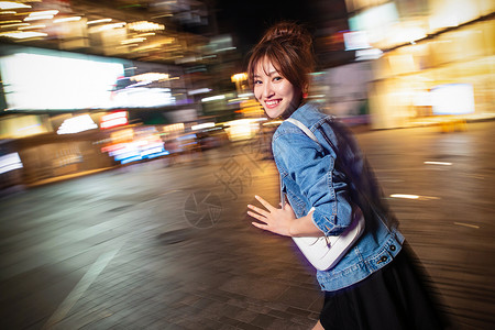 人欢乐夜晚行走的路上的青年女人图片