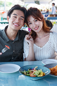 彩色图片两个人注视镜头在餐厅里用餐的青年情侣图片