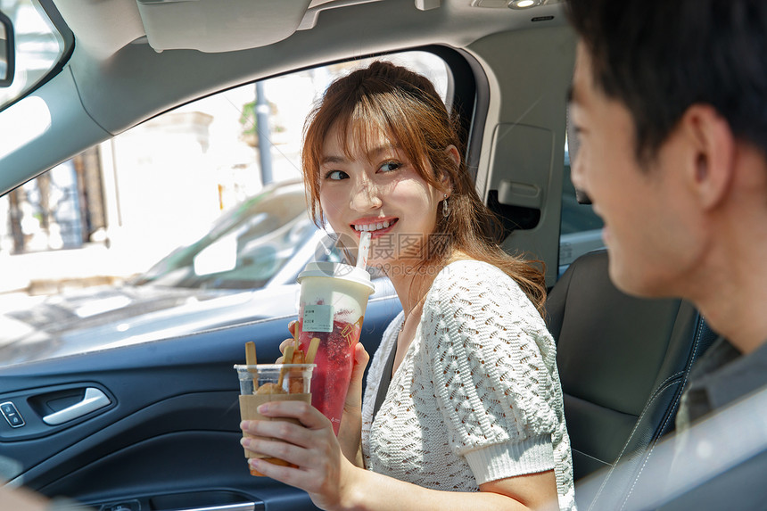 交通方式青年夫妇轻松青年伴侣坐在汽车里喝饮料图片