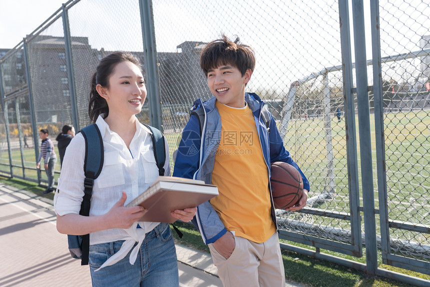 青年大学生情侣在校园里散步图片