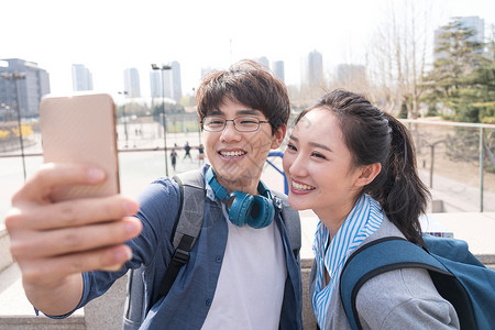 照相快乐的青年大学生情侣背景图片