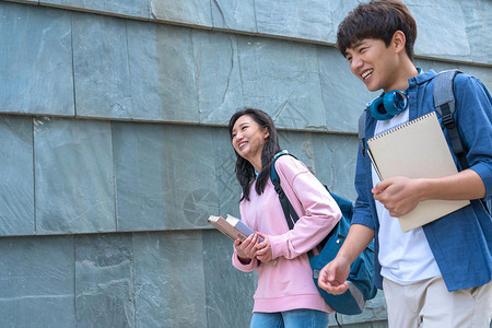 休闲装步行亚洲人大学生情侣在校园里图片