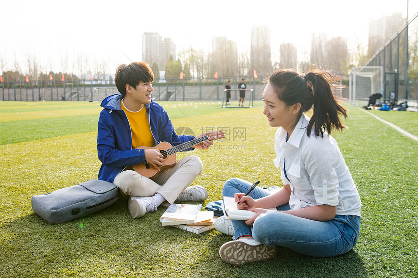 青年大学生在校园里弹奏吉他图片