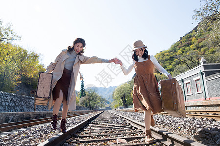 青年走自己的路青年闺蜜手牵手走在铁轨上背景