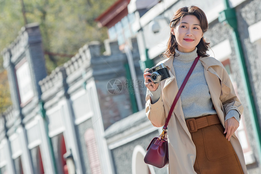 旅行的青年女人拿着照相机图片