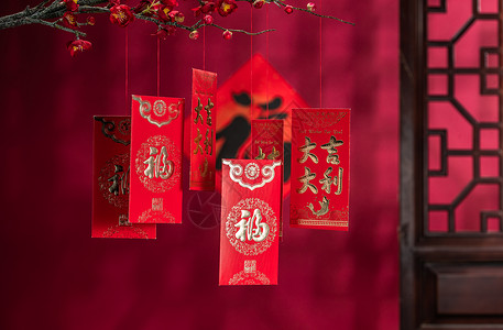 户内传统汉字悬挂在梅花下面的红包装饰品高清图片素材