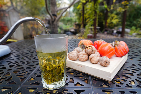 挑选茶叶桌子上的茶和柿子核桃背景