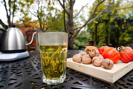 挑选茶叶庭院桌子上的茶和柿子核桃背景