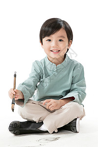 儿童服装素材准备拿着举小男孩盘腿坐着拿毛笔写字背景
