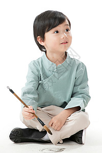 坐着写字男孩东方人留白儿童小男孩盘腿坐着拿毛笔写字背景
