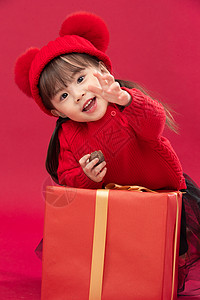 春节毛衣文化可爱的小女孩拿着新年礼物图片