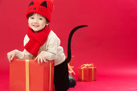 童年春节人可爱的小男孩趴在新年礼物上玩耍图片