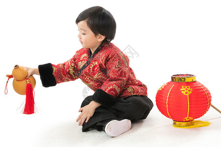 气氛传统节日彩色图片小男孩过年穿新衣服盘腿坐地上高清图片
