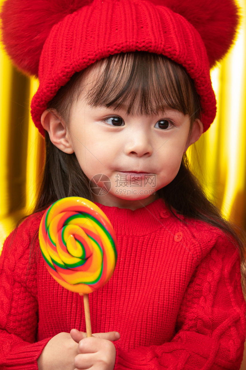 摄影拜年彩色图片小女孩过年穿新衣服手拿棒棒糖图片