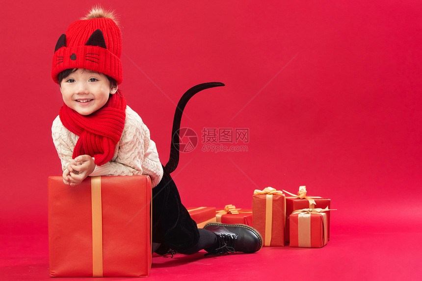 亚洲礼品祝福可爱的小男孩趴在新年礼物上玩耍图片