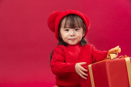 玩耍吉祥可爱的小女孩拿新年礼物上图片