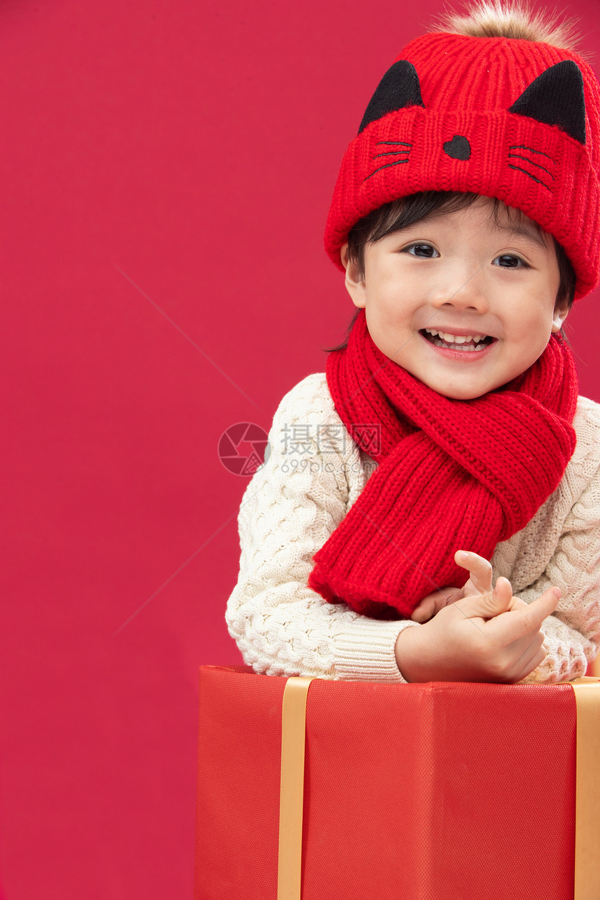 天真半身像影棚拍摄可爱的小男孩趴在新年礼物上图片