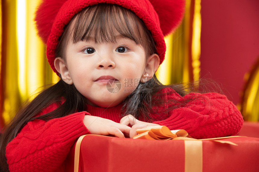 玩耍包装盒嬉戏的可爱的小女孩趴在新年礼物上图片
