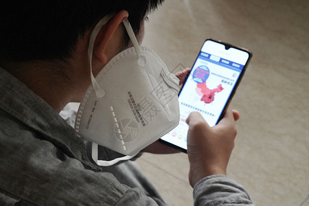 健康数据素材未成年学生居室担忧戴口罩的男孩看手机背景