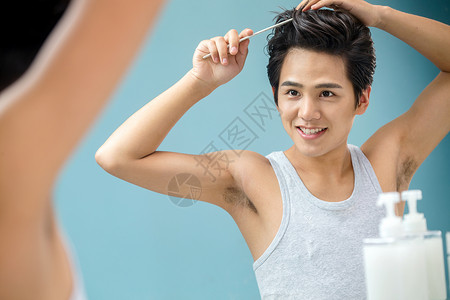 照着镜子梳头发的年轻男人图片