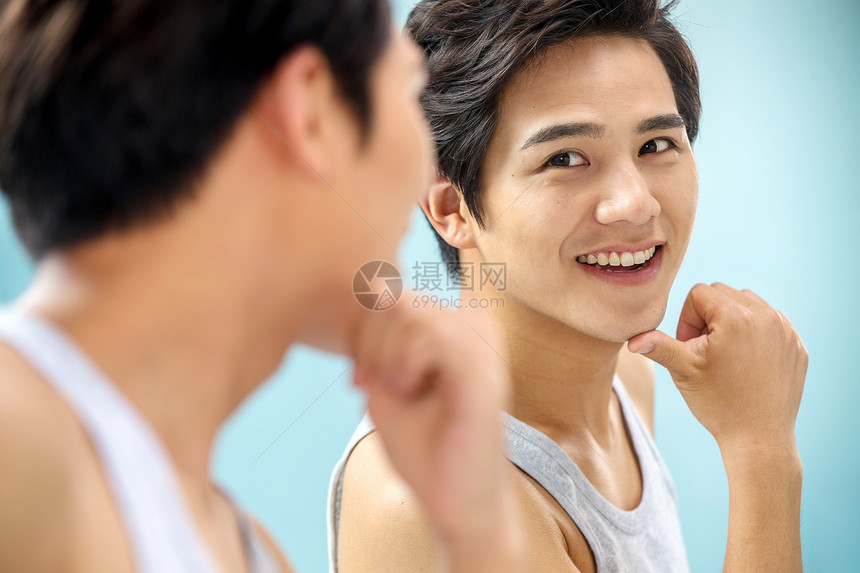 快乐的年轻男人对着镜子做手势图片
