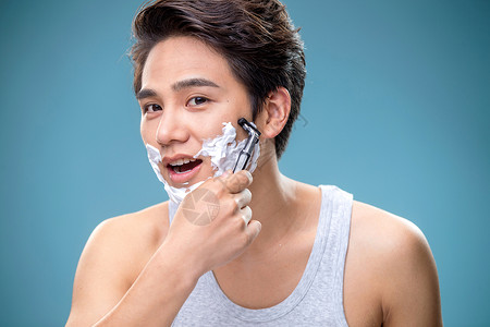 刮胡膏身体保养帅气的年轻男人刮胡子背景