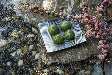 水石板传统文化彩色图片石板水面上的青团和桃花枝背景