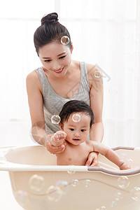 婴儿泡泡妈妈给宝宝洗澡背景