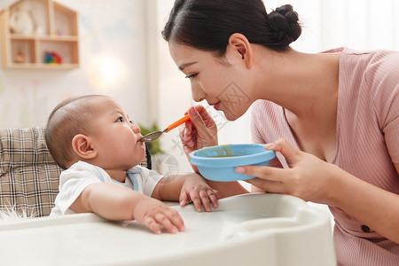 坐椅子上男孩妈妈喂宝宝吃饭背景