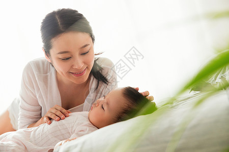 居家年轻妈妈陪宝宝睡觉保护高清图片素材