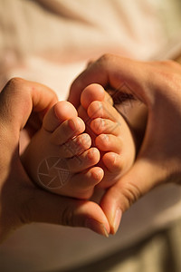 可爱女婴妈妈手捧宝宝的脚丫背景