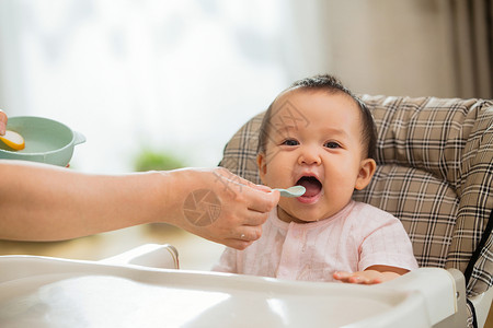 幼儿饮食婴居家年轻妈妈给宝宝喂饭背景